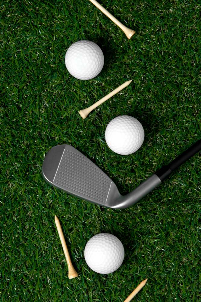 three white golf balls on green with wooden tees and a putter.