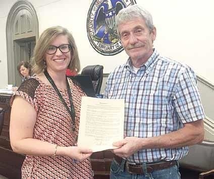 Megan Beeler, at left, vice chairman of the Montgomery County Board, presents a proclamation recognizing suicide prevention awareness to Wayne Wedekind of Crossover Ministries during the board's regular monthly meeting on Tuesday morning, Oct. 9, in Hillsboro.