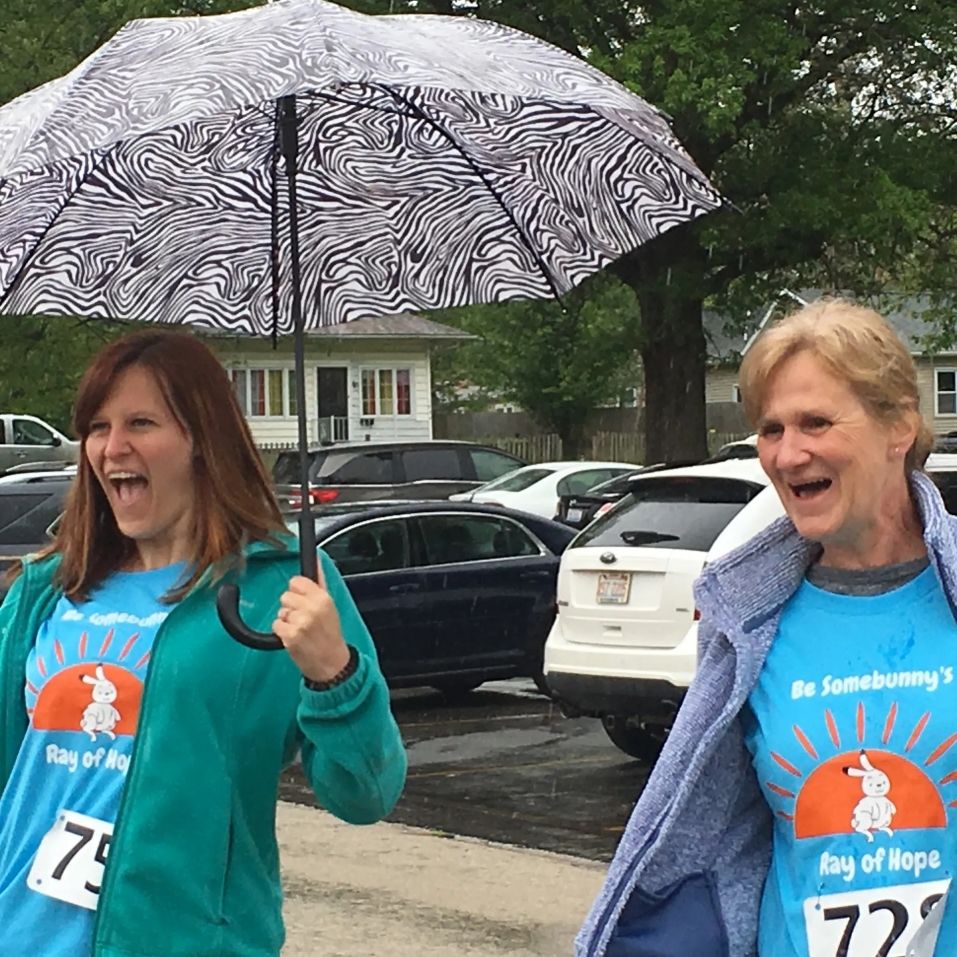 happy participants hold umbrellas at fundraising walk